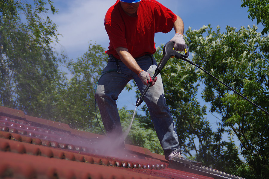 man in the roof spraying water