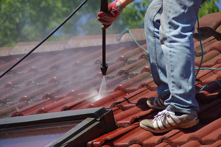 worker in the roof spraying water