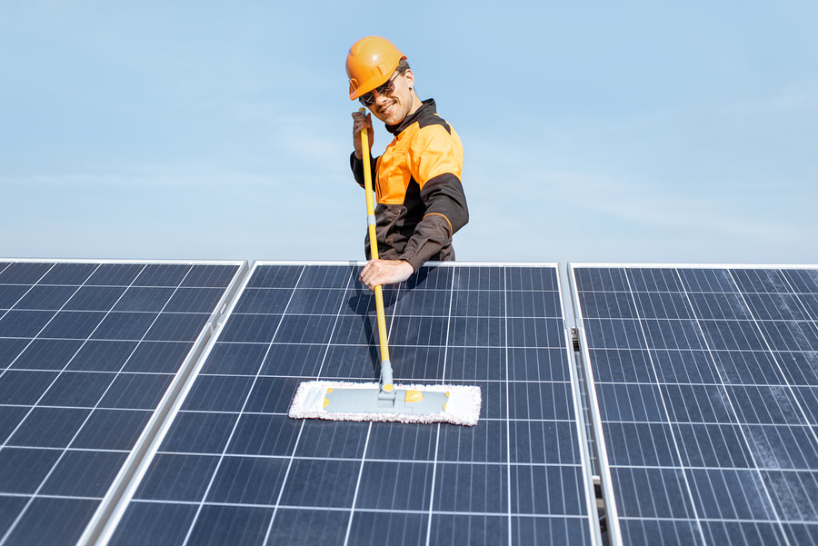 worker cleaning the solar panel